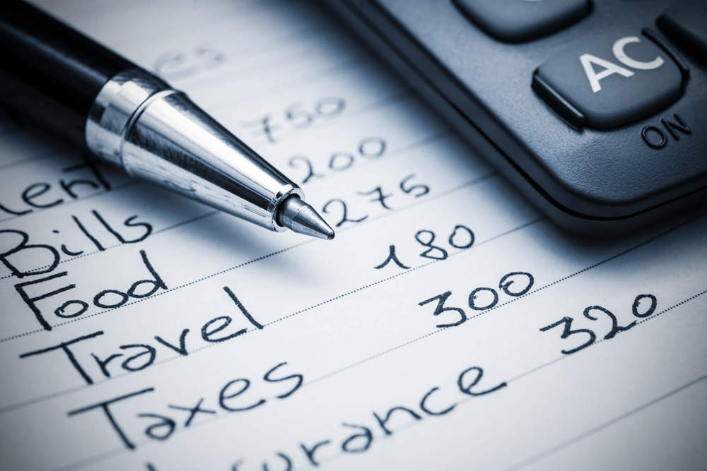 Pen resting on paper next to calculator